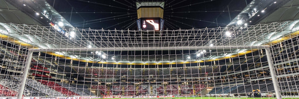 Fähnchen lassen es bunt erscheinen, aber die Arena in Frankfurt ist leer.