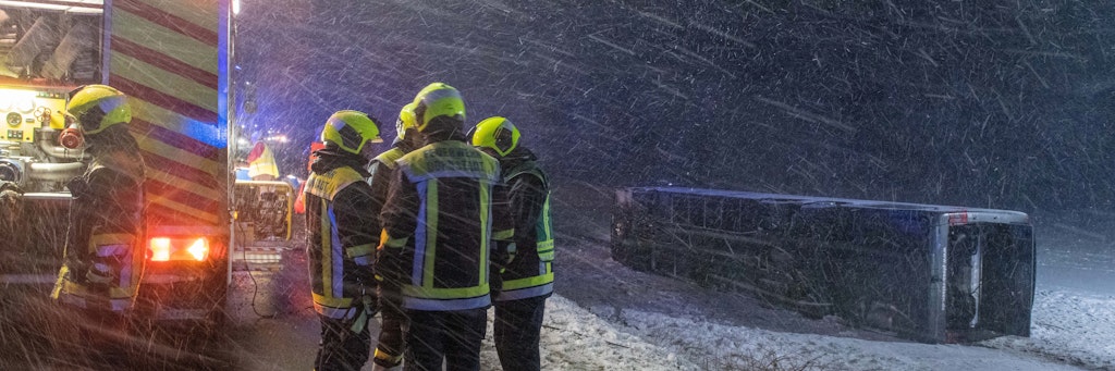 Ein Reisebus liegt umgestürzt neben der B10 in einem Feld. Bei schneeglatter Fahrbahn und starkem Wind kam der Bus von Straße ab. Acht Insassen wurden leicht verletzt.
