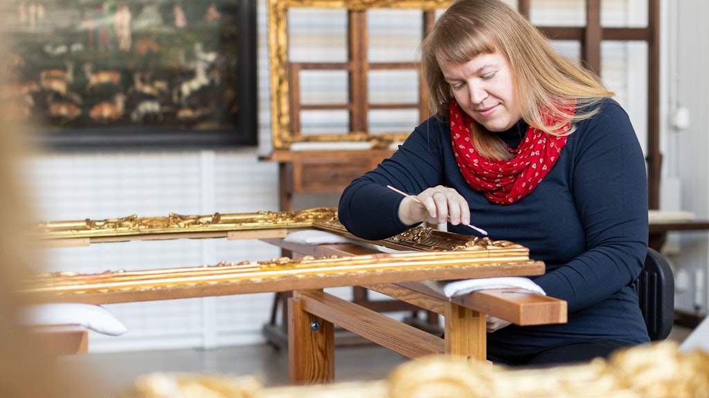 Restauratorin Elisabeth Schlesinger arbeitet an einem alten Bilderrahmen. 
