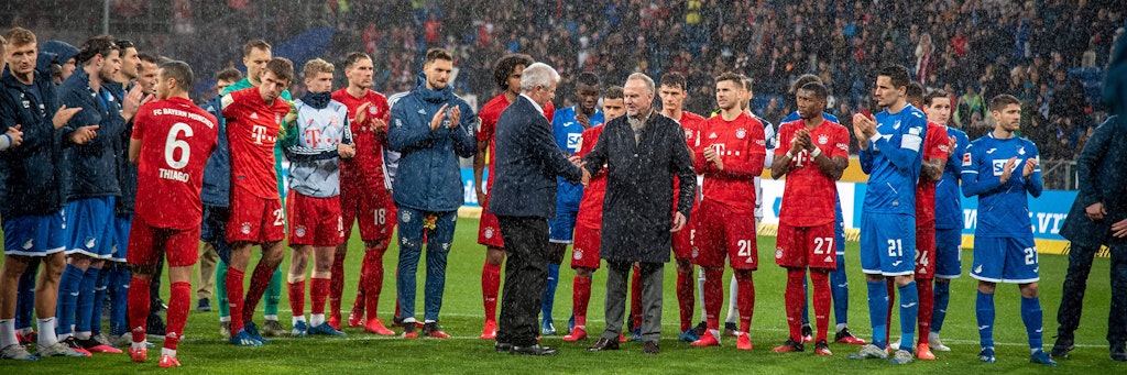 Spieler beider Mannschaften und Bayern-Boss Karl-Heinz Rummenigge und Dietmar Hopp vereint gegen die Idioten im Bayern-Fanblock.