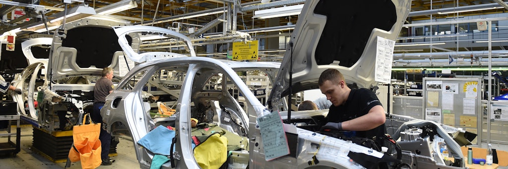 Mitarbeiter von Mercedes-Benz arbeiten im Werk in Bremen an einer C-Klasse.