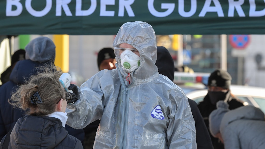 Polnische Sicherheitskräfte in Schutzkleidung messen am Grenzübergang Stadtbrücke die Körpertemperatur von Personen, die einreisen wollen.
