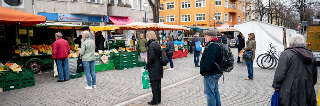 Auf dem Wochenmarkt in Friedenau halten Käufer Abstand - nicht überall halten sich die Berliner an die Vorsichtsmaßnahme. 