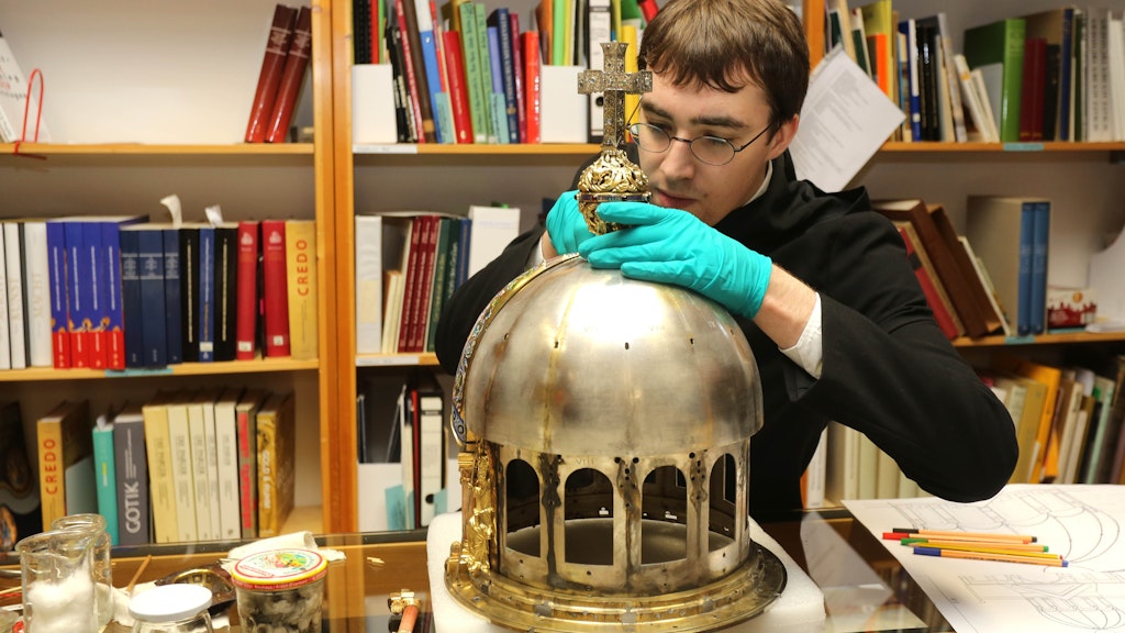 Luke Jonathan Koeppe, Student der Restaurierungs- und Konservierungswissenschaft, reinigt und konserviert den Schrein der Heiligen Corona.