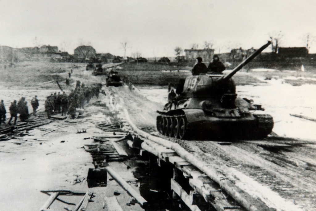 Auf nach Berlin! Russische Panzer rollen mittels einer Behelfsbrücke über die Oder, abgelöste Infanterie marschiert von der Front ins Hinterland.