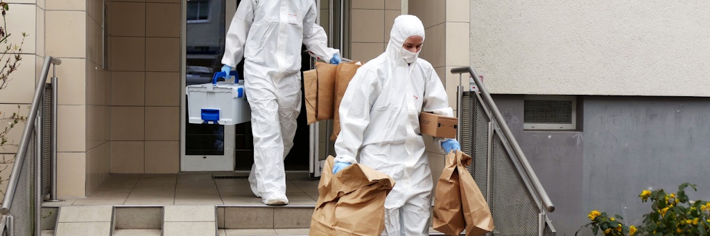 Spezialisten der Spurensicherung tragen am Dienstag in Tüten gesichertes Beweismaterial aus dem Tathaus in der Borkheider Straße in Marzahn.