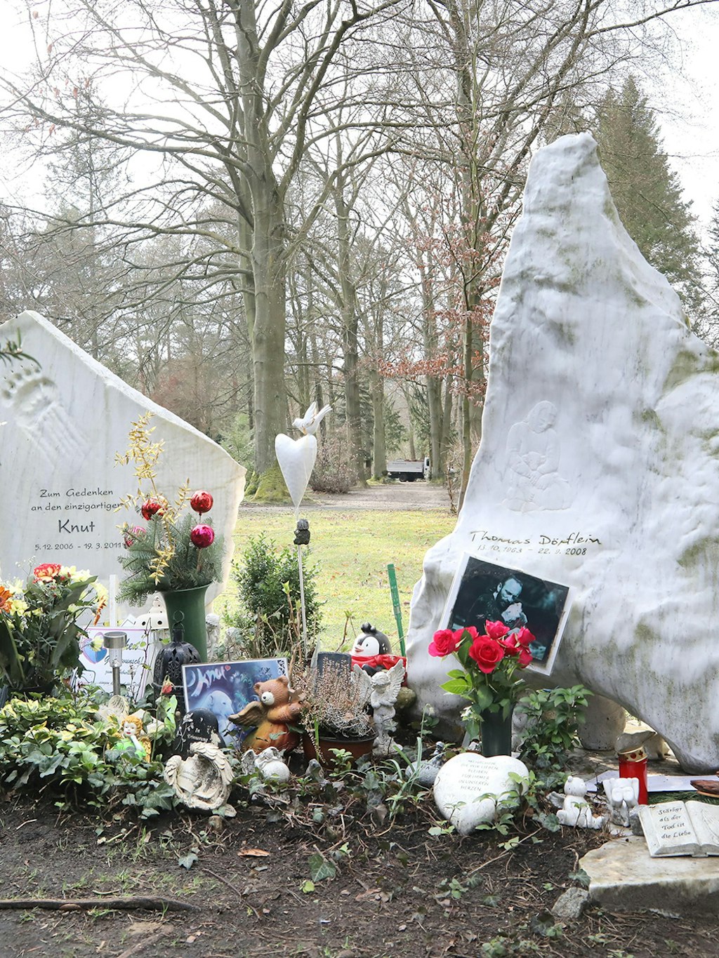 Ein Knut-Gedenkstein und Dörfleins Grabstein stehen nebeneinander auf dem Friedhof.