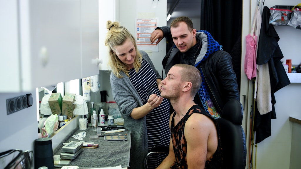 Eric Stehfest (hinten) besucht Schauspieler Jannik Schümann in der Maske am Set bei den Dreharbeiten zu der Buchverfilmung "9 Tage wach". Die Maskenbildnerin Sylvia Grave macht Schümann für die Rolle des Eric Stehfest zurecht.