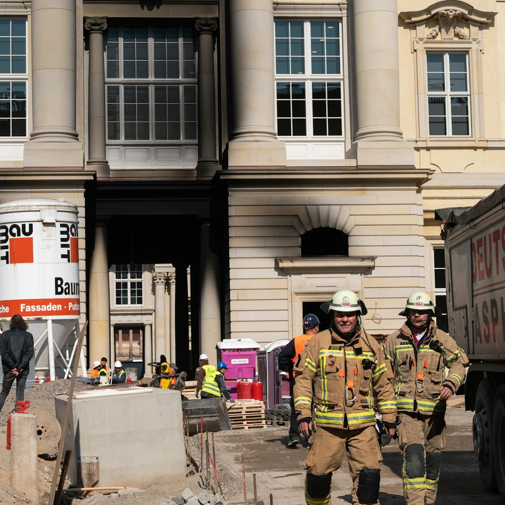 Die Fassade an der Südseite des neuen Stadtschlosses ist verrußt, Feuerwehrleute rücken ab, nachdem sie die brennenden Bitumen-Kocher gelöscht hatten.