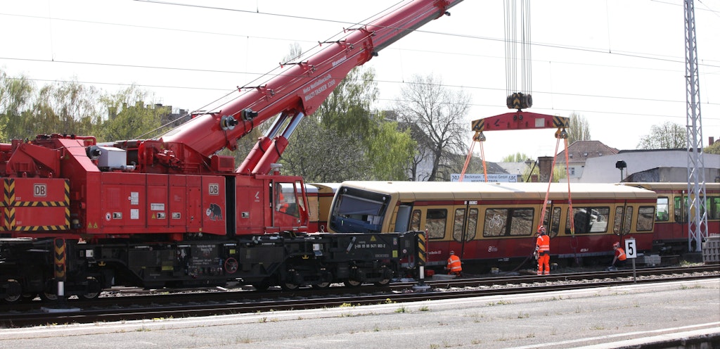 Ein Kran hebt einen Waggon des verunglückten S-Bahnzugs an.