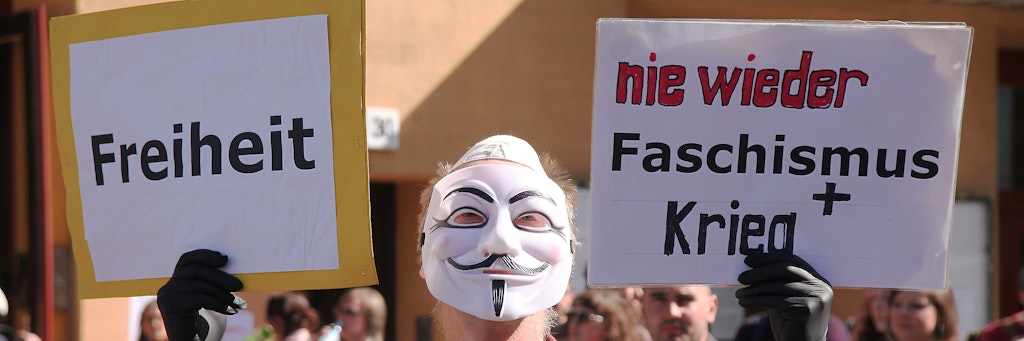 Ein Demo-Teilnehmer trägt eine Maske.