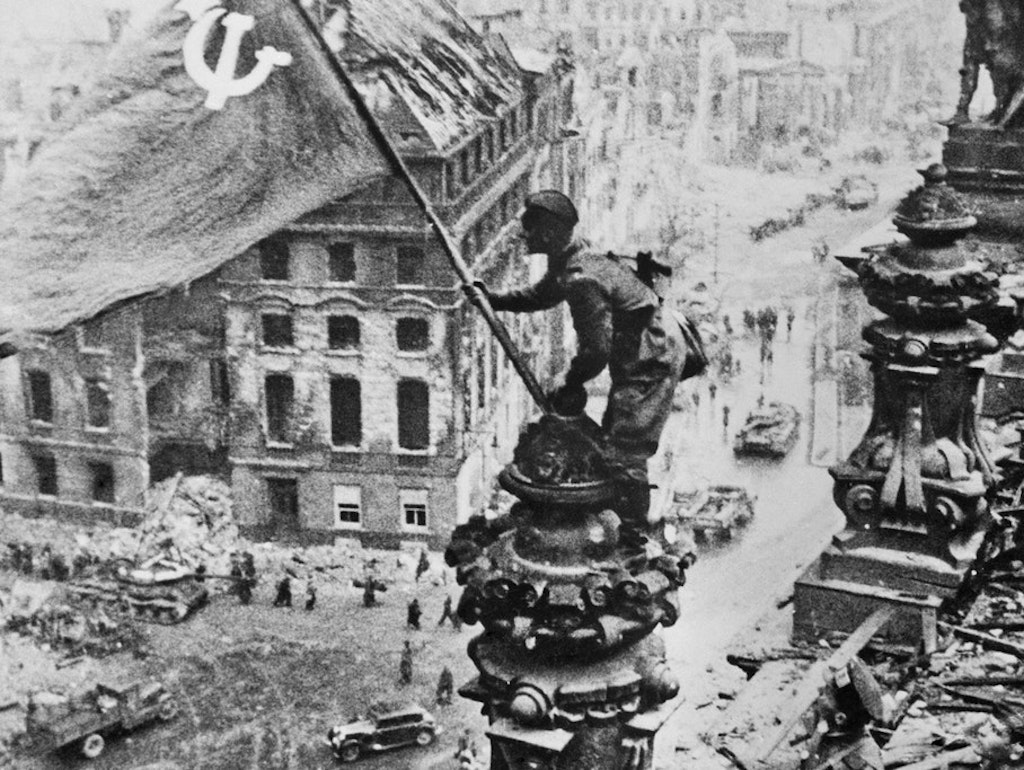 Ein sowjetischer Soldat hisst auf dem Reichstagsgebäude die Rote Fahne. Dieses Foto stammt aus einer Serie von 36 nachgestellten Aufnahmen, die der Kriegsberichterstatter Jewgenij A. Chaldej am Morgen des 2. Mai 1945 schoss.
