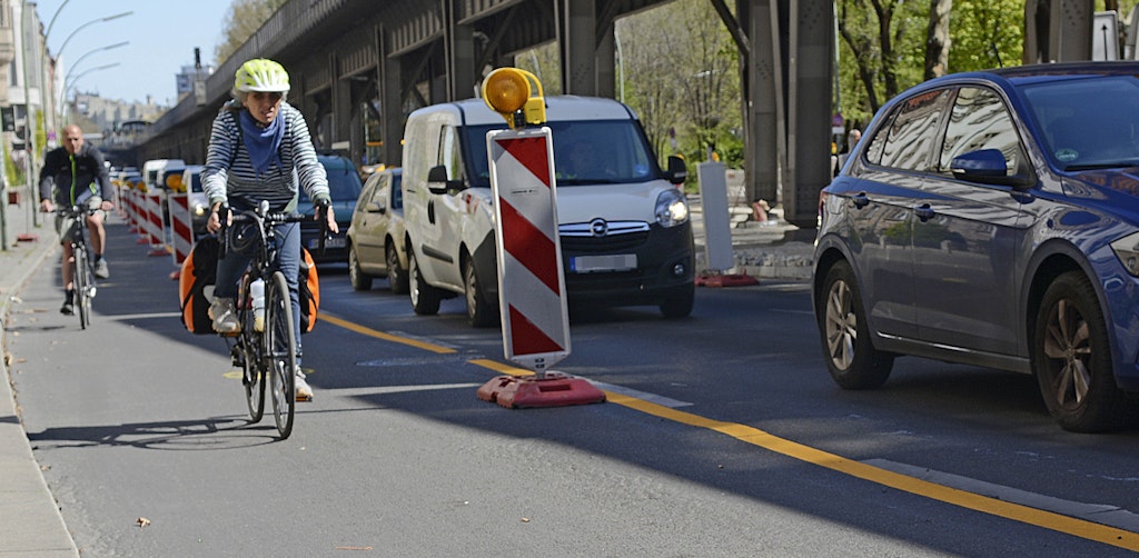 Mit gelben Streifen und Warnbaken ist der temporäre Radfahrer-Streifen der Gitschiner Straße in Kreuzberg abgegrenzt, Zweiräder kommen schneller voran als Autos. 
