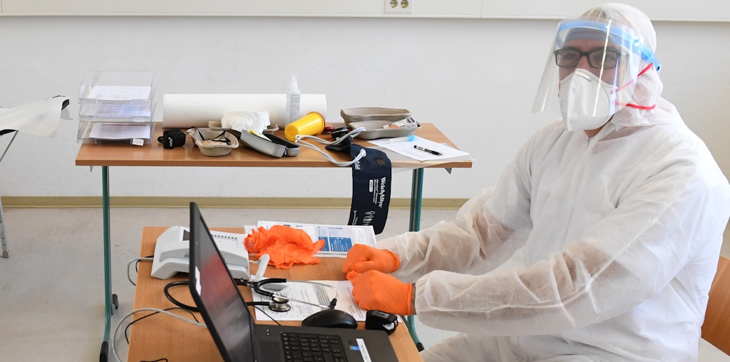 Ein Arzt im Vollschutz wartet auf Patienten: In Greifswald (Mecklenburg-Vorpommern) wurde von der Universität und dem Landkreis bereits eine Fieberambulanz eingerichtet, die ein ähnliches Angebot wie jetzt die Covid-19-Praxen in Berlin bereitstellt.