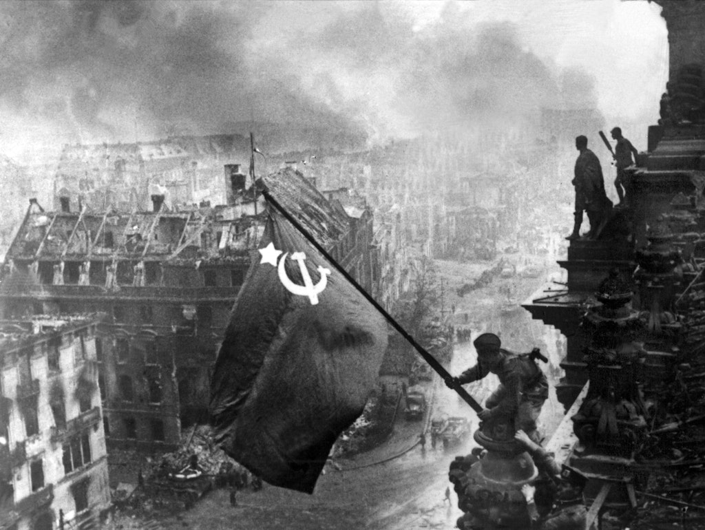 Die Rote Fahne, das Banner der Sowjetunion, weht auf dem Dach des Reichstags in Berlin. Kriegsberichterstatter Jewgenij Chaldej stellte das Hissen der Flagge am Morgen des 2. Mai in Szene und dramatisierte das Foto zusätzlich durch die Montage von Rauchschwaden in den Himmel. Ein Sowjetsoldat hatte bereits am späten Abend des 30. April eine rote Fahne auf dem Gebäude gehisst.