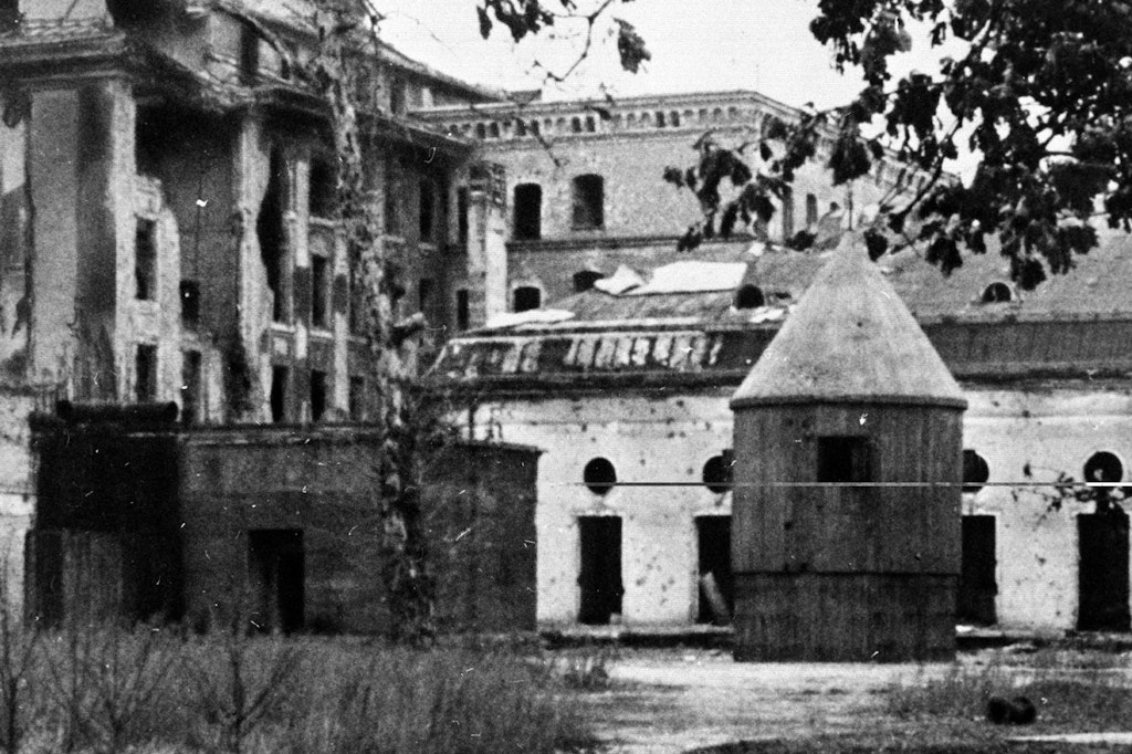 Blick in den Garten der Reichskanzlei: Links befindet sich der Notausgang und rechts steht der Wachturm des „Führerbunkers“, dahinter liegen der große Festsaal der Alten Reichskanzlei und, links davon, das Reichsaußenministerium. Die Leichen Hitlers und Eva Brauns wurden hier verbrannt.