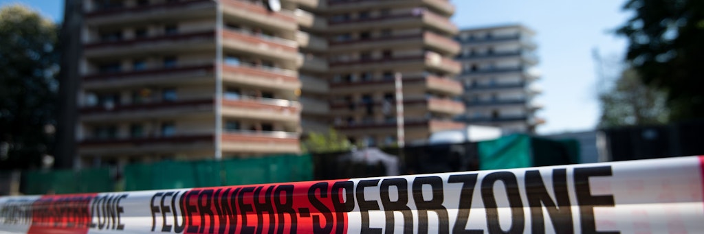 Der abgesperrte Wohnkomplex in Grevenbroich. Weil zwei Familien trotz Corona-Infektionen ihre Quarantäne in den Hochhäusern verlassen haben, werden nun alle Bewohner der 117 Wohnungen getestet. 