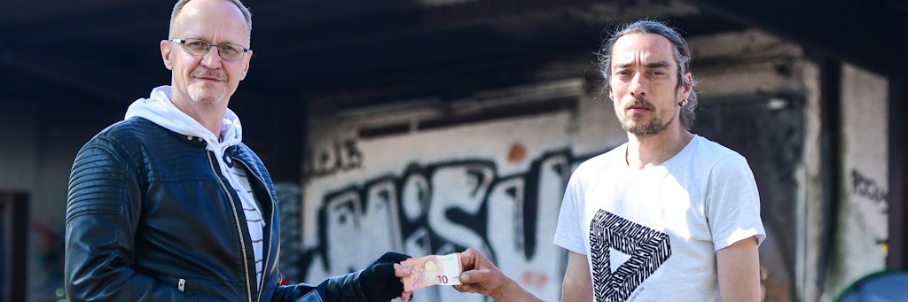 Der ehemalige Obdachlose André Hoek verteilt Geldspenden an Bedürftige auf der Straße, hier zehn Euro an Dirk (46). 
