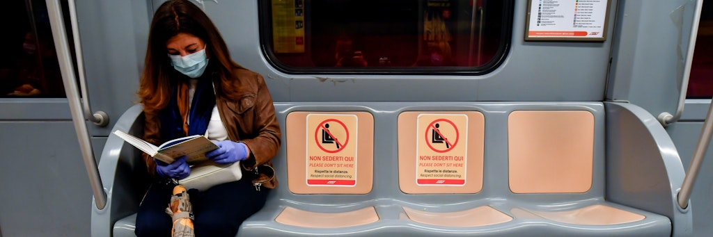Shutdown in Italien: Eine Frau sitzt mit Maske in einer U-Bahn in Mailand.