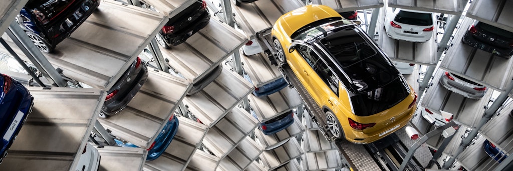 Ein Volkswagen T-Roc steht auf einer Hebebühne in einem Autoturm auf dem Werksgelände von Volkswagen.