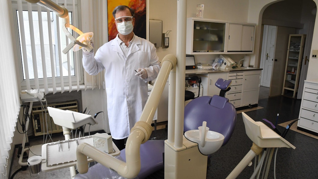 Dr. Dreyer mit Maske und Schutzbrille - aber ohne einen Patienten auf dem Stuhl.