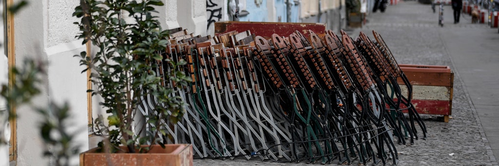 30.03.2020, Berlin: Gastronomie-Stühle stehen hochgeklappt an einem Haus in der sonst so belebten Simon-Dach-Straße in Berlin-Friedrichshain. Aufgrund der Corona-Pandemie sind Cafés und Restaurants geschlossen. Foto: Britta Pedersen/dpa-Zentralbild/dpa +++ dpa-Bildfunk +++