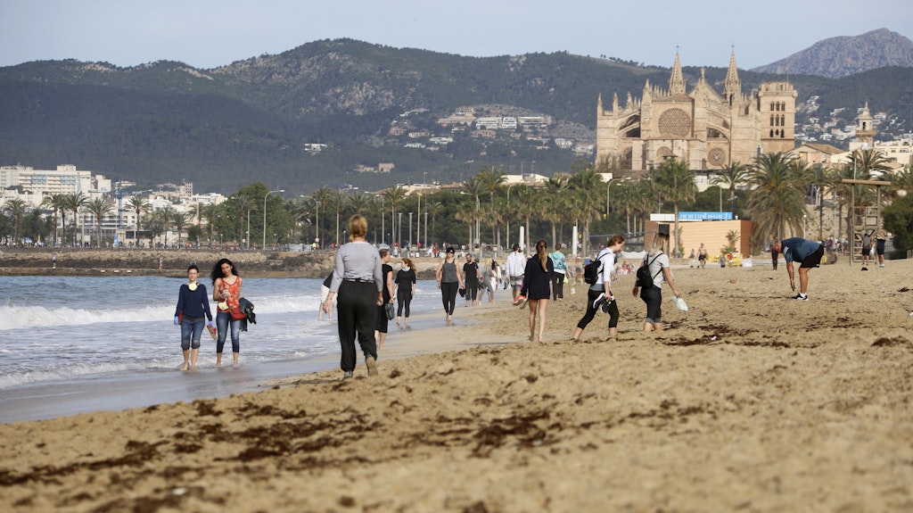 Spaziergänger am Strand "Can Pere Antoni" in Palma de Mallorca. Die Ferieninsel lockert schon den Shutdown: Ab Montag dürfen Hotels öffnen.