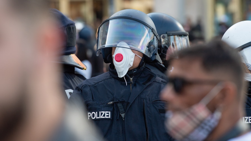 Bei einer Demonstration auf dem Alexanderplatz am 9. Mai steht ein Polizist mit einer Atemschutzmaske. Mehrere Hundert Menschen hatten sich am Samstagnachmittag am Alexanderplatz zu einer nicht angemeldeten Zusammenkunft versammelt. 