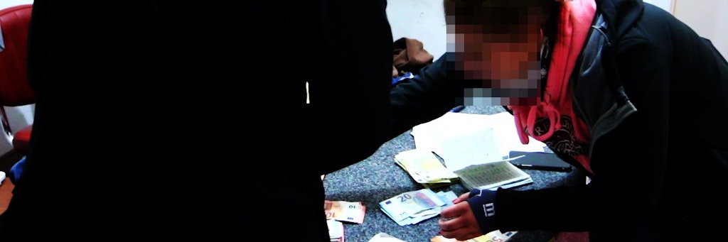Eine Beamtin der Berliner Polizei untersucht bei dem Einsatz in Neukölln beschlagnahmten Geldscheine. 