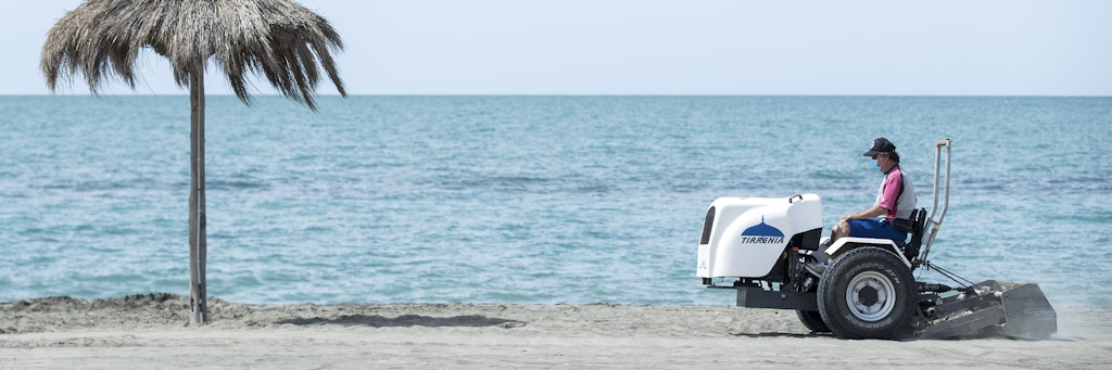 Ein Arbeiter mit Mundschutz macht einen Strand in Italien für die Saison fertig.