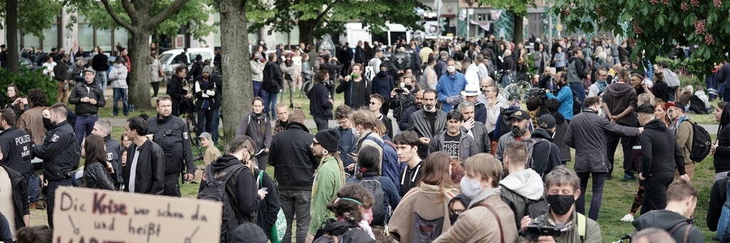 Demonstranten versammeln sich auf dem Oranienplatz in Kreuzberg. Kaum jemand hält Abstand, viele Menschen tragen keinen Mundschutz.
