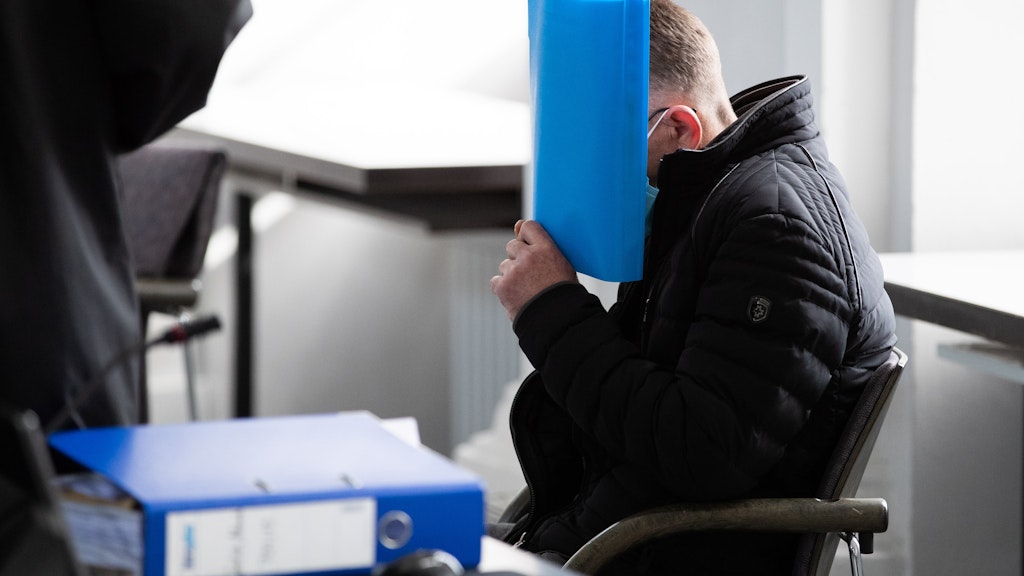 Der Angeklagte sitzt vor der Gerichtsverhandlung auf seinem Platz.