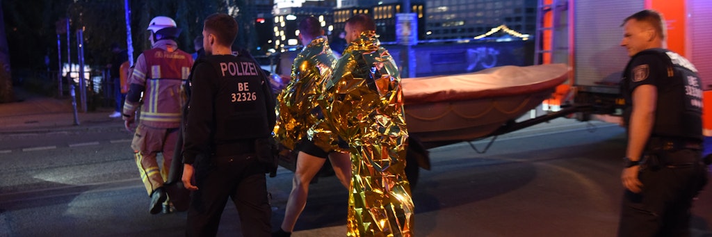 Die Polizisten hüllen sich nach ihrer Rettungstat in Wärmedecken .