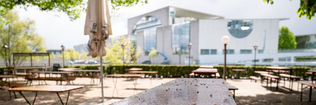Leere Tische und Bänke stehen in einem Biergarten vor dem Bundeskanzleramt. Ein Bild, wie es in den vergangenen Wochen vielerorts zu sehen war. Nun sollen neue Lockerungen kommen - die Corona-Diät in Kneipen und Restaurants könnte also bald vorbei sein.