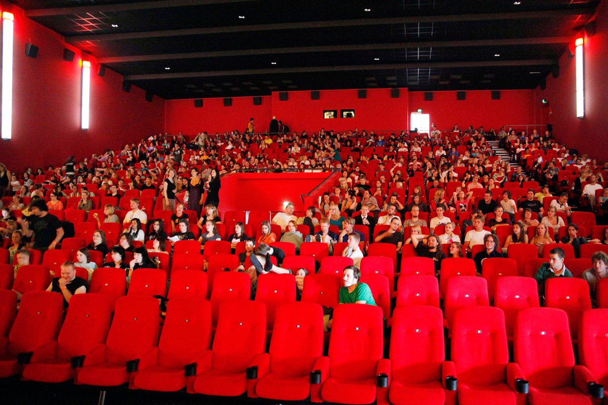 Der Kinosaal leert sich in einer kurzen Pause zwischen zwei Filmen. Vorne vor der unteren Stuhlreihe schlafen zwei Potter-Fans.