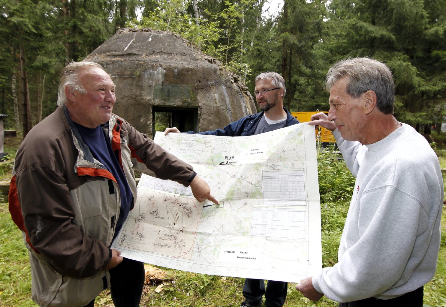 Der letzte Dispatcher der DDR-Marine Erich Vierow, Gelände-Besitzer Mario Ruhm und Pächter Claus Funke (von links) zeigen einen geheimen Bunkerverteidigungsplan.