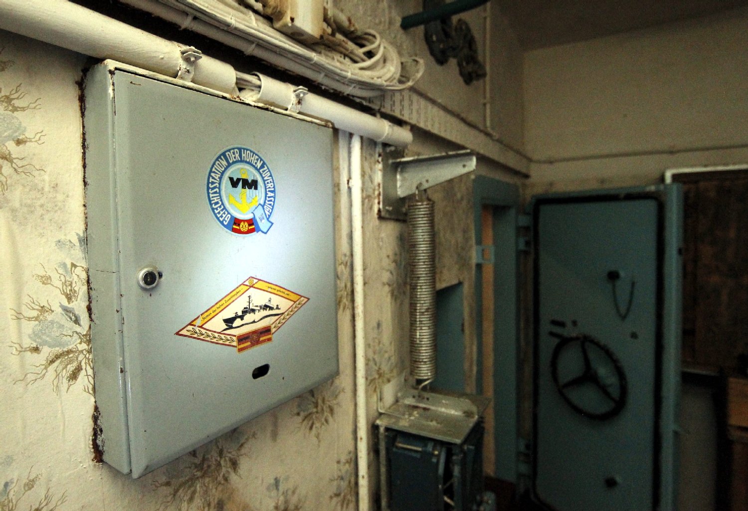 Ein Aufkleber der DDR-Marine mit der Aufschrift "Gefechtsstation der hohen Zuverlässigkeit" hängt an einem Schaltkasten für die Schleuse des Bunkers.