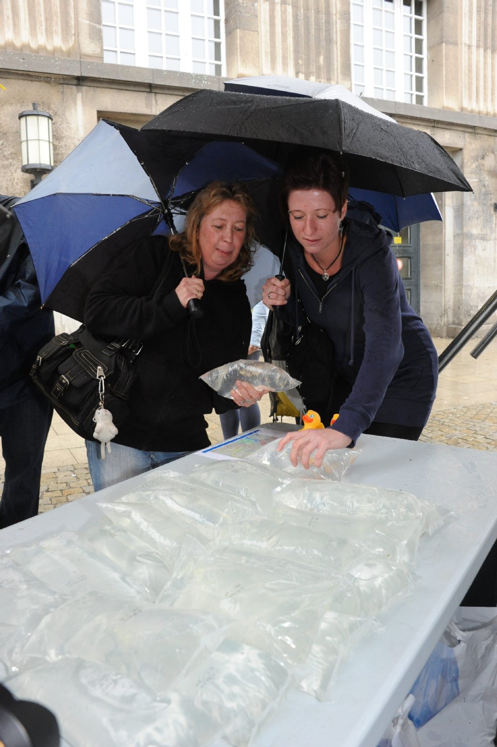Auch Janka Heymann (49) und Carita Herzfeld (30) holen sich Not-Beutel am Wasser-Mobil ab.