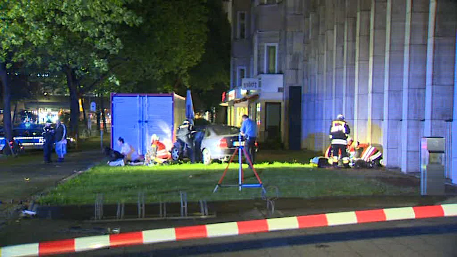 Verletzte weinen, auf der Wiese steht der Unfall-Opel.