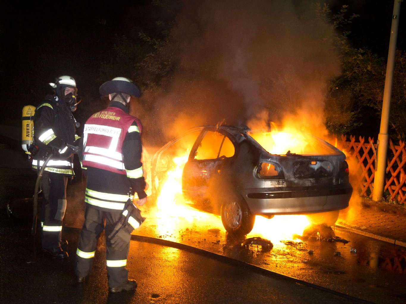 Feuerwehrmänner müssen mit ansehen, wie ein Auto von den Flammen aufgefressen wird. Seit Anfang der Woche brannten rund 70 Fahrzeuge.