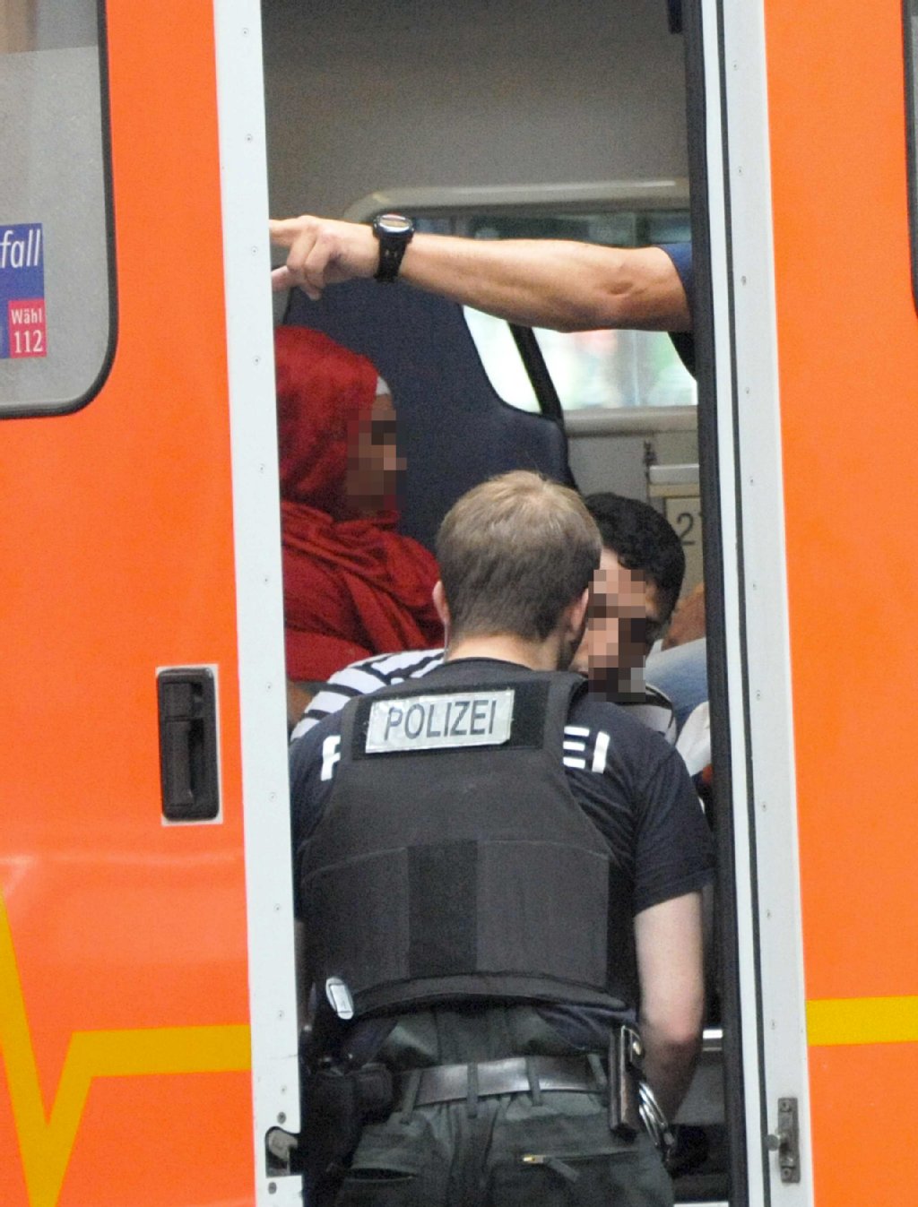 Die Ex-Frau (rotes Kopftuch) des Schützen sitzt geschockt im Rettungswagen.