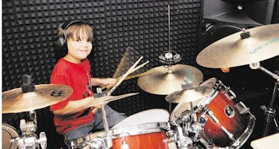 Glücklich lächelt Jakob hinter seinen Drums zu Hause.