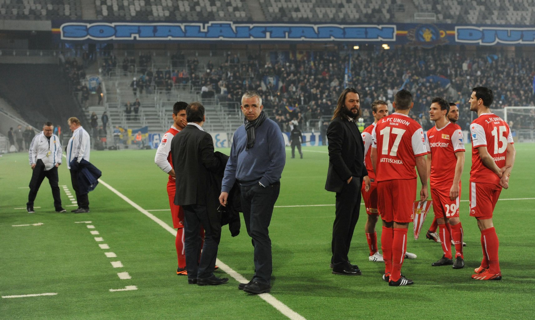 Union-Boss Dirk Zingler (3. v. l.) kann die Randale nicht fassen, seine Spieler stehen mit Pressechef Christian Arbeit (M.) ratlos auf dem Rasen.