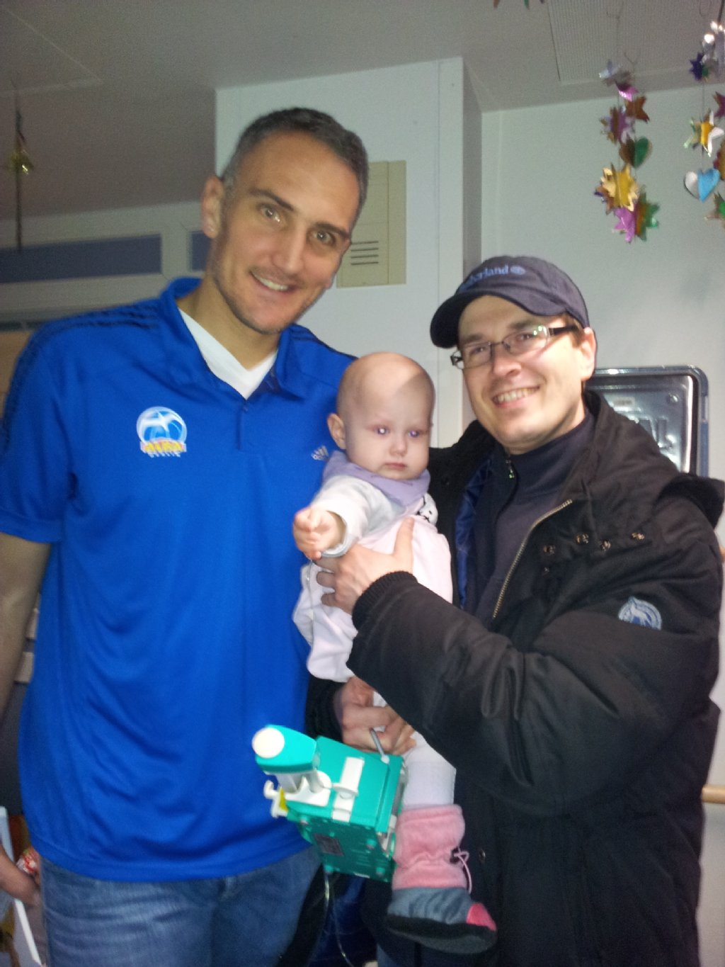Von links: Sven Schultze von ALBA mit Neele und Papa Gerald G. auf der Kinderkrebsstation im Dezember.