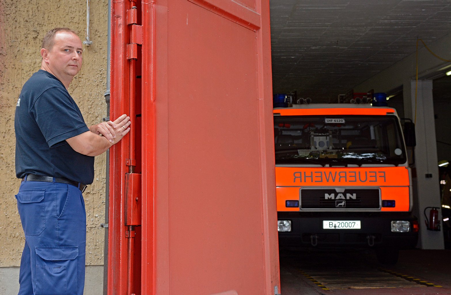 Wehrleiter Thomas Wache mit dem „Tor des Anstoßes“: Zwei Mann müssen es bei Wind sichern, damit die Wagen zum Einsatz überhaupt aus der Garage fahren können.
