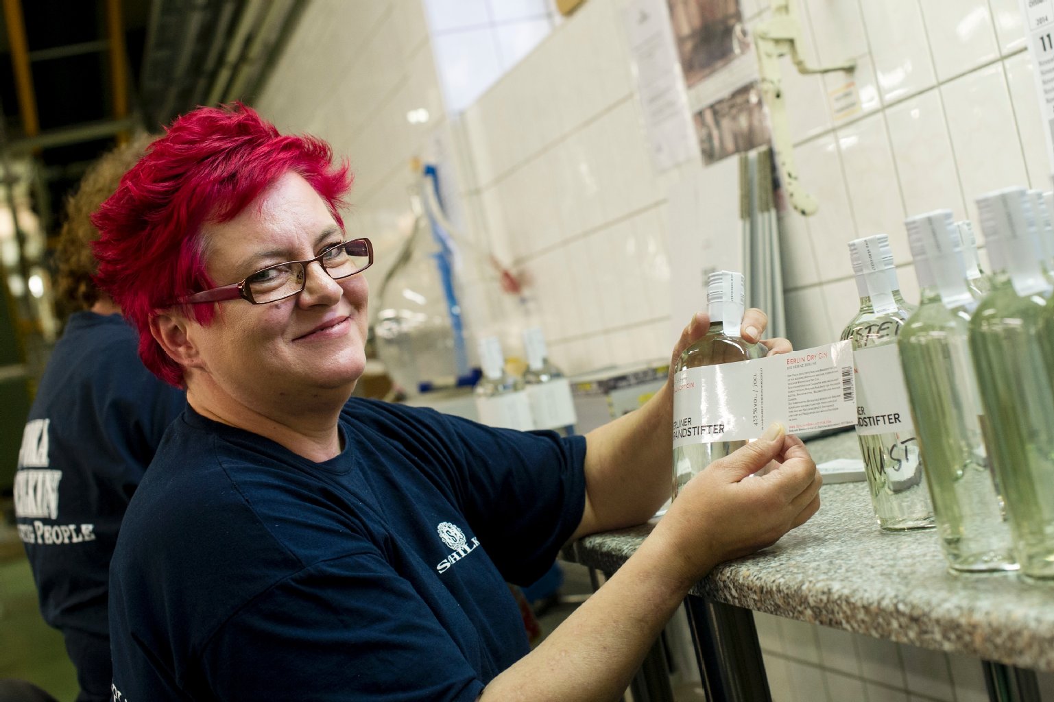 Edda Sponholz arbeitet seit mehr als 30 Jahren bei Schilkin. Hier klebt sie in Handarbeit Etiketten auf Flaschen des Schilkin-Gins „Berliner Brandstifter“.