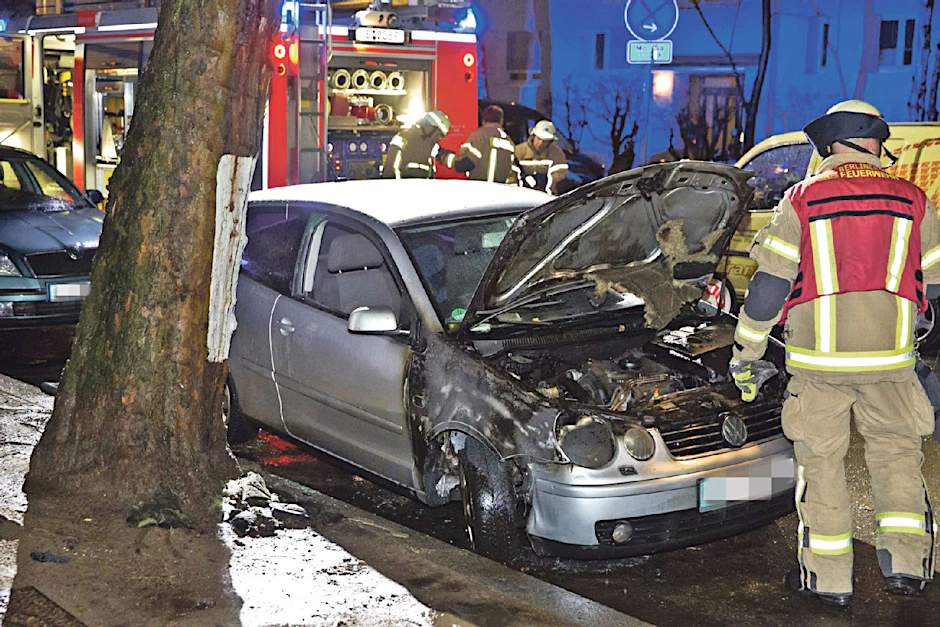 Ein Feuerwehrmann steht an dem völlig zerstörten Fahrzeug.