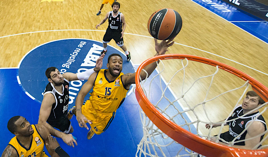 Albas Reggie Redding (Nr. 15) versenkt vor Madrids Ioannis Bourousis (2.v.l.) den Ball im Korb.