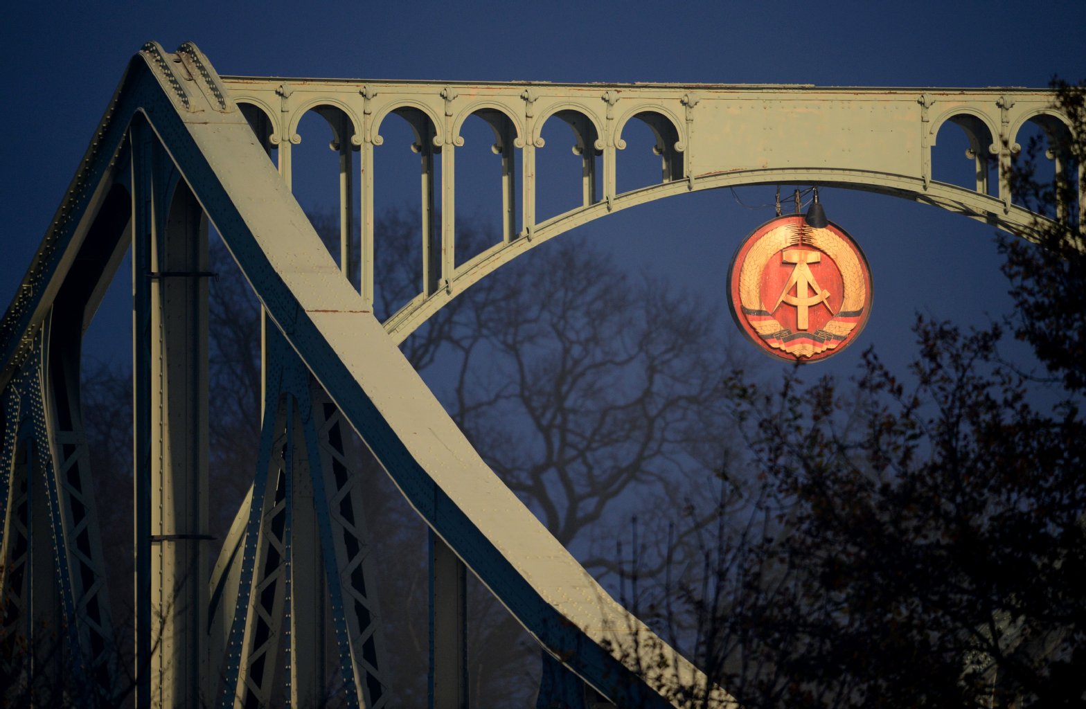 Das Wappen der ehemaligen DDR hängt am 28.11.2014 in einem Bogen auf der mit nachgebauten Grenzkulissen aus dem Jahr 1962 dekorierten Glienicker Brücke