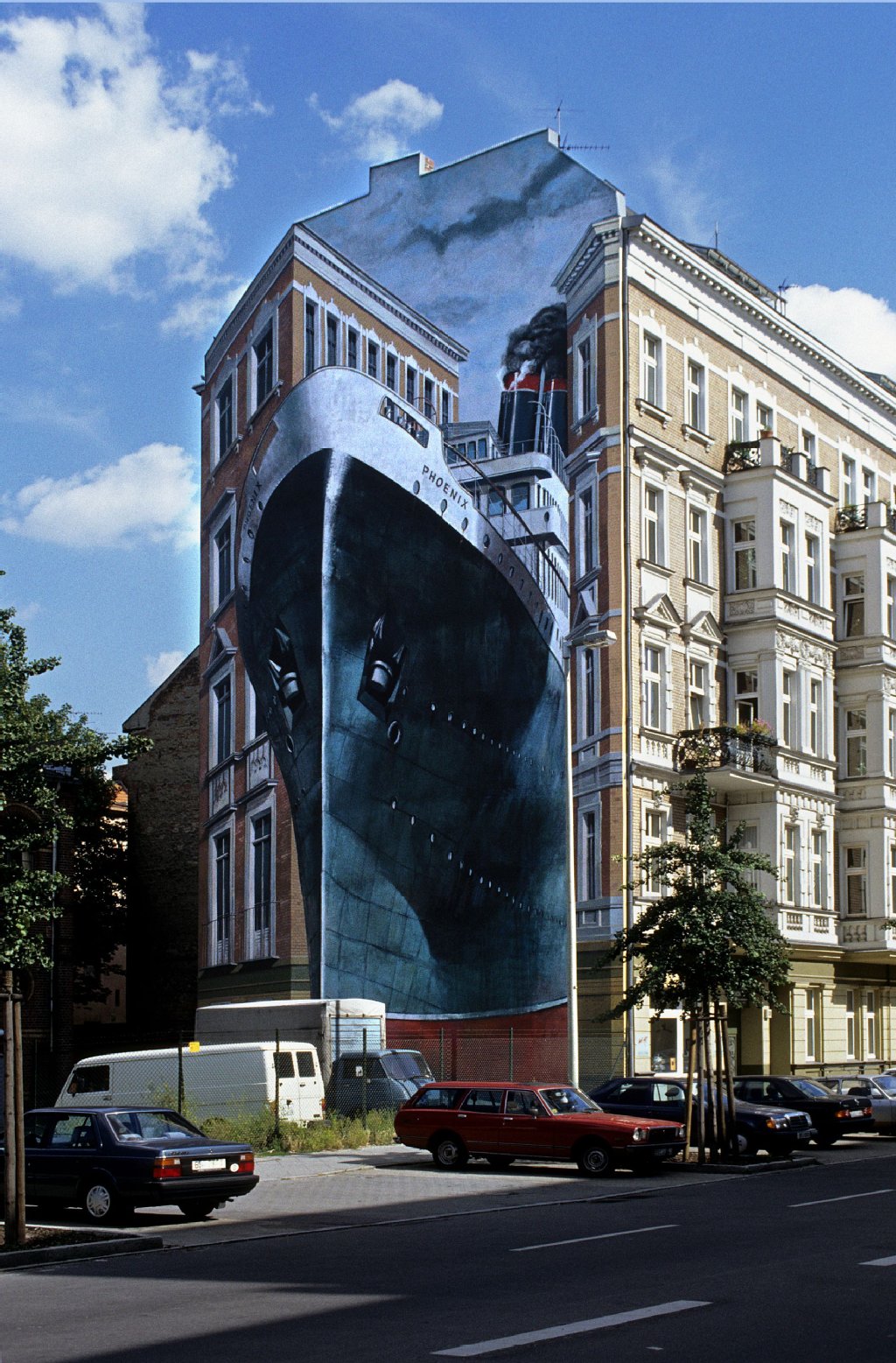 Phoenix (1989): Eines von Martins Lieblingswerken stellt tatsächlich die „Phoenix“ dar. Das Gemälde in der Wintersteinstraße 20 wirkt durch die Häuserfront besonders echt und dreidimensional.